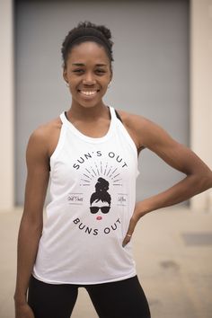 a woman is smiling and posing for the camera with her hands on her hips while wearing a white tank top that says, too