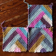 two crocheted squares sitting on top of a wooden floor