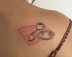 a woman with a tattoo on her back has a plate and cup next to it