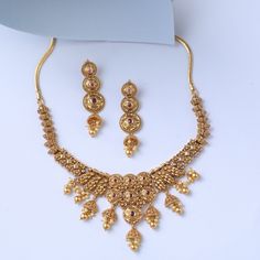 Description Inspired by the shimmering Indian gold jewelry. This Collection is designed to highlight fine Indian craftsmanship. It is crafted in gold-plated 925 silver with intricate textures and tones. Modern designs adorn you with timeless floral patterns. This jewelry is perfect for wedding and festival events. Brimming with festive elegance, the Jhumki Silver Necklace Set is a timeless piece. The design features jhumki charms all around, shining with pearl drops and pink stones. Suspended fr Yellow Gold Round Temple Necklace With Meenakari, 22k Gold Jewelry For Diwali, Gold Hallmarked Kundan Necklace For Diwali, Yellow Gold Round Kundan Temple Necklace, Yellow Gold Round Kundan Necklace Temple Jewelry, Yellow Gold Round Kundan Necklace In Temple Style, Gold Hallmarked Chandbali Temple Necklace, Intricate Kundan Jewelry Sets, Bollywood Style Yellow Gold Temple Necklace Gift