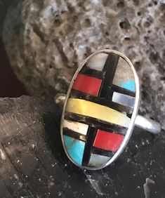 Vintage sterling Zuni ring with stone to stone inlay of coral, turquoise, shell, and onyx. There are slight gaps in places in the inlay. The ring is interesting, and I believe old. The artisan has chosen to include more gray matrix than turquoise in one panel. This is a soulful and colorful little artisan made ring. The ring is size 6-1/4. The face of the ring is .75 inches long and .47 inches wide. It weighs 3 grams. Artisan Oval Multi-stone Turquoise Ring, Handmade Artisan Multicolor Turquoise Ring, Handmade Multicolor Artisan Turquoise Ring, Unique Multicolor Turquoise Cabochon Ring, Unique Multicolor Cabochon Turquoise Ring, Multicolor Natural Stone Turquoise Ring In Sterling Silver, Multicolor Natural Stones Turquoise Ring In Sterling Silver, Multicolor Turquoise Ring With Natural Stones In Sterling Silver, Unique Oval Multi-stone Turquoise Ring