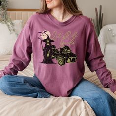 Get spooky this season with our Can-Am Spyder Halloween-themed cozy long sleeve crew neck T-shirt! Featuring the bold "Let's Ride Girls" text, this shirt showcases a witch holding a staff, a haunting moon with bats, and a detailed Can-Am Spyder motorcycle graphic in classic Halloween colors of purple, black, and green. Perfect for female riders who love the Halloween vibe, this T-shirt is a must-have for your fall wardrobe or Halloween events. Comfortable and stylish, it's the ideal gift for Can-Am enthusiasts ready to ride into the spooky season! This classic unisex jersey short sleeve tee fits like a well-loved favorite. Product Details Made with 100% ring-spun cotton, these personalized long-sleeve shirts come packed with softness and style. Each tee features garment-dyed fabric and com Moon With Bats, Halloween Colors, Halloween Events, Classic Halloween, Halloween Long Sleeve, Girls Halloween, Crew Neck Tshirt, Cooling Blanket, Bike Week