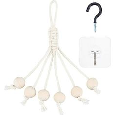 an assortment of white and black balls hanging from a string with a hook in the middle