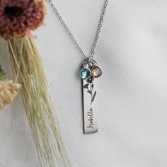 "FLOWER NAME NECKLACE: Personalize your necklace by selecting your flower variety and name to be engraved. We offer 12 blooming flower varieties to represent the 12 months of the year. Customize it further by adding optional birthstone charms, which add an extra layer of elegance. -THE PERFECT GIFT: This bar necklace makes the perfect gift for Mother's Day, Valentine's Day, birthdays, anniversaries, and Christmas. Choose her favorite flower or the flower that is symbolic to her. -STYLE: The clas May Birthstone Necklace With Flower Charm For Mom, Birthstone Necklace With Birth Flower Pendant For Mom, Mother's Day Birthstone Necklace With Birth Flower For Mom, Personalized Birthstone Necklace With Birth Flower, Flower-shaped Birthstone Necklaces For Mother's Day, Personalized Gifts For Mom, Birthday Woman, Birthstone Charms, Birthstone Necklace