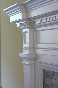 the corner of a white fireplace mantel with moldings on it's sides