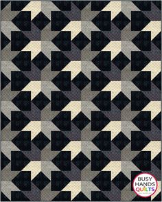 a black and white quilt with many squares on the front, one in grey and two in beige