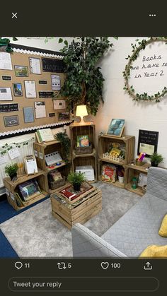 the room is decorated with books and plants in crates on the floor, as well as several other wooden boxes