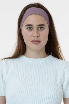 a woman wearing a white sweater and purple headband