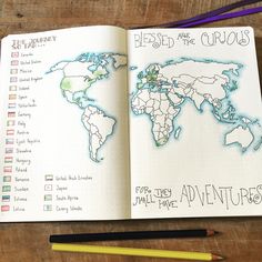 an open notebook with a world map drawn on it and pencils next to it