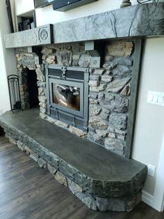 a stone fireplace with a tv above it