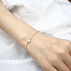 Embrace understated elegance with our "Kendall Bracelet." This delicate and dainty piece features a single diamond on a slender chain, exuding a timeless beauty that is both pretty and refined. Perfect for everyday wear or special occasions, this bracelet effortlessly adds a touch of subtle sparkle and sophistication to any outfit. Nickel, lead, alloy, brass free Hypoallergenic Waterproof Anti-tarnish 10 inches Jewelry Care Sterling Silver To make the most out of your newest addition, we recomme Classic Everyday Gold Bracelet With Cubic Zirconia, Minimalist Hypoallergenic White Gold Chain Bracelet, Minimalist Sterling Silver Pearl Bracelet, Dainty Gold Bracelet With Cubic Zirconia And Adjustable Chain, Gold Minimalist Diamond Bracelet For Everyday, Minimalist Gold Diamond Bracelet For Everyday, Adjustable Dainty Diamond Bracelets, Everyday Delicate Sterling Silver Pearl Bracelet, Minimalist Hypoallergenic Diamond Jewelry