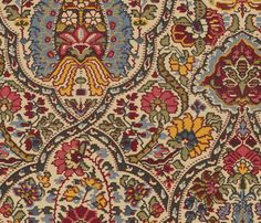 an old rug with many different colors and designs on it's surface, including flowers