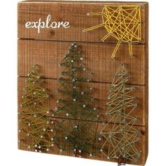 string wrapped christmas trees are displayed on a wooden board with the word explore written above them