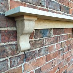 a wooden shelf on the side of a brick wall