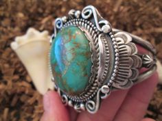 "A beautiful Navajo old pawn solid sterling silver and genuine Royston Turquoise cuff bracelet. The large stone is of a deep Caribbean Sea blue/green with caramel color matrix swirling through it. There is Navajo roping and dotting around the stone base, and very detailed silver design surrounding it, very well done! This cuff is all handwrought with no mass produced pieces. Made in the 70's, this is Navajo old pawn, and in excellent condition. It measures 2 1/4\" from north/south and about 2 1/ Antique Stamped Turquoise Jewelry, Southwestern Style Round Turquoise Cuff Bracelet, Vintage Turquoise Cuff Bracelet Stamped 925, Southwestern Turquoise Cuff Jewelry, Vintage Turquoise Cuff Bracelet, Vintage Turquoise Sterling Silver Cuff Bracelet, Luxury Southwestern Kingman Turquoise Cuff Bracelet, Vintage Nickel-free Turquoise Cuff Bracelet, Native American Turquoise