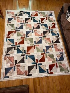 a living room with a couch and a quilt on the floor