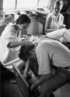 three people in a room with one laying on the floor