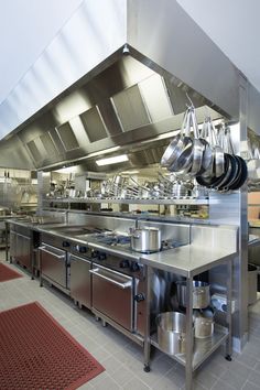 an industrial kitchen with pots and pans hanging from the ceiling