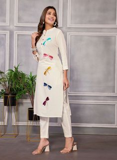 Elevate your ethnic wardrobe with this stunning embroidered kurta suit set crafted from pure linen. The kurta pant set includes a straight kurta with a mandarin neck, 3/4 sleeves, front button placket, and beautiful butterfly thread embroidery. The pant features a partially elasticated waist for added comfort and style. Perfect for any festive occasion or special event, this ensemble is sure to make you stand out in the crowd. Fitted Linen Straight Kurta Set, Spring Cotton Traditional Wear With Mirror Work, Spring Traditional Cotton Wear With Mirror Work, Spring Traditional Wear With Mirror Work, Chanderi Pant Set With Chikankari Embroidery And Straight Kurta, White Sets With Mirror Work For Spring, Linen Straight Kurta With Resham Embroidery, Linen Kurta With Resham Embroidery, Straight Linen Kurta With Resham Embroidery