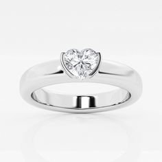 a white gold ring with a heart shaped diamond in the center, on a white background