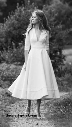 a woman in a white dress is walking down a path