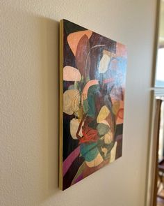 an abstract painting hangs on the wall