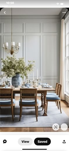 the dining room table is set with blue and white plates, candles, and flowers