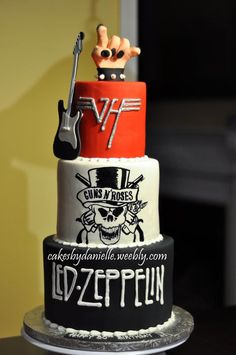 a three tiered cake decorated with guitars and music related words on it's sides