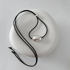 🫘Minimalist Black Cord Necklace with Silver Bean Pendant 🫘 Made with a black leather-like string cord and featuring a bold chunky bean pendant in sterling silver. The self-adjustable length allows for personalized comfort and style. The minimalist design and simple, clean lines make it a versatile accessory that complements any outfit, making it an ideal choice for summer wear. **This Made-to-Order necklace may take up to 2-3 weeks to dispatch if silver components are temporarily unavailable. Ear Cuff Piercing, Cord Choker, Black Cord Necklace, Minimalist Summer, Black Rope, Outfit Making, Bracelet Collection, Pendant Silver, Cord Necklace