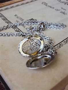 This is a beautiful vintage oval locket necklace. The locket has ornate openwork filigree on the front, with a starburst design in the middle, and a textured design on the back. It is silver plate, with a great antique silver hue. The chain is 18 in. long, and is a textured link design. The locket is 1 in. long including the bail, and 3/4 in. wide. The necklace is in great new unused condition, and is a nice style for layering with more chains! Thank you for looking! Antique Silver Locket Necklace With Charms, Silver Antique Locket Necklace With Charms, Vintage Compass Pendant Jewelry, Oval Metal Locket Necklace, Vintage Round Compass Jewelry, Vintage Silver Locket Necklace With Charms, Silver Vintage Locket Necklace With Charms, Metal Oval Locket Necklace, Vintage Gold Necklace With Compass Design