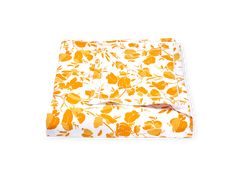 an orange and white floral print sheet set on top of a white bed spreader