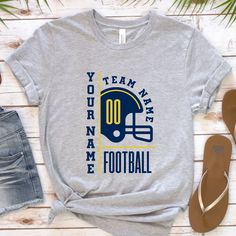 a t - shirt that says team name football with a helmet on it