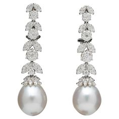 An elegant pair of pearl and diamond dangle earrings. 1.50 carats of white round brilliant cut diamonds set into round and marquise shapes with a pearl drop. 18k white gold Approximately 1.6 inches long A timeless pair of earrings! White Diamond Pearl, White Gold Drop Earrings, South Sea Pearls Earrings, Diamond Cluster Earrings, White Pearl Earring, Luxury Earrings, Pearl And Diamond Earrings, Diamond Dangle Earrings, Diamond Chain