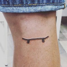 a small tattoo on the ankle of a person with a skateboard attached to it