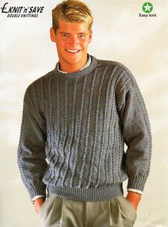 a man wearing a gray sweater and khaki pants in front of a white background