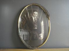 a portrait of a man in a suit and tie on a mirror with rope around it