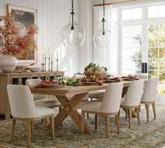 a dining room table with chairs and plates on it