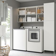 a washer and dryer in a room with open shelves on the wall next to each other