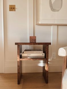 a small wooden table with books on it