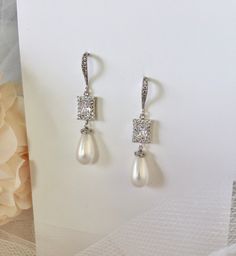 Elegant. Classic. Perfect. Featuring 15mm teardrop shell pearls (natural), this elegant pair of earrings will add glamour to any wedding dress or formal ensemble. All it takes is a simple glance at this unique design to see its extremely classy look that makes an elegant and feminine statement. Shining brightly and quite eye-catching, the shimmer of the pearls is given an extra boost by the clear cubic zirconia that adorn them. Length: 2" (approx. 5cm); Width: 0.4" (approx. 1cm); Weight: 6g. Ava Elegant Pearl Clip-on Earrings For Formal Occasions, Elegant Pearl Drop Clip-on Earrings, Elegant Pearl White Pearl Clip-on Earrings, Elegant White Clip-on Earrings With Pearl Charm, Elegant White Pearl Drop Clip-on Earrings, Elegant Pearl White Clip-on Earrings With Pearl Drop, Elegant Pear-shaped Pearl Earrings For Anniversary, White Pearl Drop Clip-on Earrings For Wedding, Classic White Pear-shaped Bridal Earrings