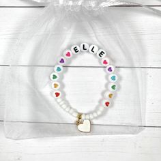 This colorful heart bracelet makes a great birthday gift! The white beads and heart charm make the heart beads pop! Personalize this bracelet for someone you love ❤️ The bracelets are beautifully packaged and ready to gift. Receipts are never included in your package. If you want to include a special note, please let me know in the comments. Roll, don't pull. To avoid excess stretching please roll the bracelet on and off. Treat and store the bracelets gently. Sizing options are just a guideline. Kids Name Bracelet, Bracelet For Kids, Girls Bracelet, Bracelets Charm, Fun Bracelet, Bracelet Heart, Baby Bracelet, Presents For Kids, Great Birthday Gifts