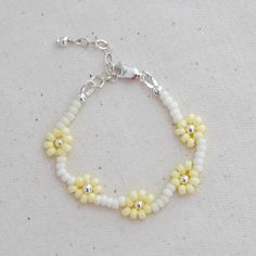 Our daisy chain beaded bracelets can be personalised with an initial or symbol disc add on. They are the sweetest keepsake jewellery for your little ones. Lovingly hand beaded using only high quality seed beads. Metal hardware options : 14k Gold filled, 14k Rose gold filled or Sterling Silver. Each bracelet comes with an extra 0.5" extension chain so your little one can still wear their bracelet as they get older. Handcrafted in Australia. Each piece is hand stamped & there may be slight variati White Delicate Adjustable Friendship Bracelets, Delicate Adjustable White Friendship Bracelets, Delicate White Adjustable Friendship Bracelets, Adjustable Daisy Everyday Jewelry, Adjustable Flower-shaped Jewelry With Letter Beads, Delicate White Beaded Round Bracelets, White Daisy Jewelry For Everyday, White Daisy-shaped Everyday Jewelry, Everyday White Daisy Shaped Jewelry