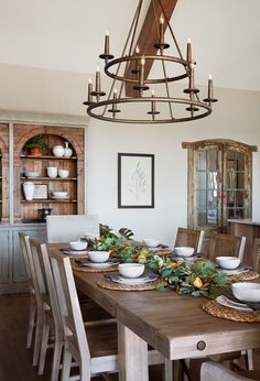 a dining room table with plates and bowls on it