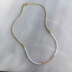 Our lithe necklace is handcrafted with a touch of gold in a minimalist style. •Seed beads in your choice of color combination •Hand strung in a modern pattern•14kt Gold-Filled beads & spring clasp •16 inches in length or 16 inches with a 2 inch extender Everyday White Single Strand Necklace, Minimalist Gold Beaded Necklaces With Tiny Beads, Everyday White Single Strand Beaded Necklace, Yellow Gold Necklaces With Tiny Beads For Everyday, Minimalist Adjustable Beaded Necklace With Gold Beads, Handmade Delicate Beaded Necklaces For Everyday, Everyday Beaded 14k Gold-filled Necklaces, Delicate Handmade Beaded Necklaces, Everyday Beaded 14k Gold-filled Necklace