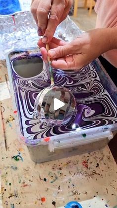 a person is painting on a box with paint