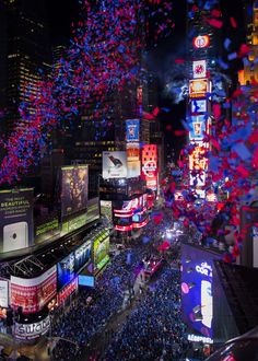 confetti is thrown in the air over a crowded city street at night time