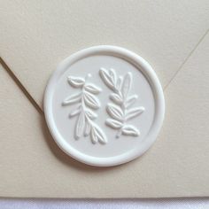 an envelope with a wax stamp depicting leaves on the front, and a letter in the back