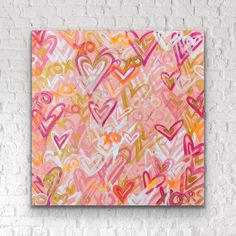 an abstract painting on a brick wall with pink and yellow hearts in the center, against a white brick wall