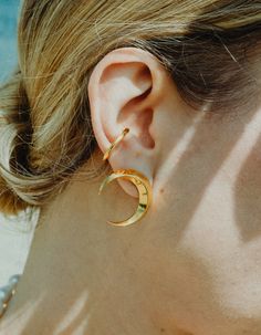 Symmetrical moon-shaped earrings made of sterling silver or sterling silver plated with 24 ct gold. Motif diameter: 24 mm. Decorative engraving on the reverse.We observe the phases of the Moon on Earth trying to solve the mystery of lunar attraction, but one side of this peculiar celestial body is always hidden in the shade of the Sun. Celestial Gold Plated Moon Earrings, Gold Moon-shaped Cartilage Earrings, Gold Single Moon-shaped Earring, Gold Moon Shaped Cartilage Earrings, Minimalist Moon Shaped Single Earring, Gold Crescent Earrings With Moon Phase Detail, Modern Crescent Brass Earrings, Gold Moon Phase Earrings, Moon-shaped Hoop Earrings As Gift