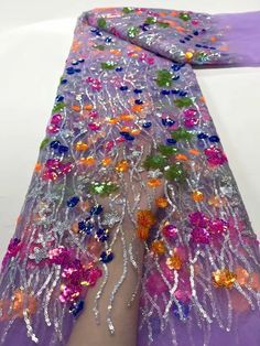 a woman's leg with colorful sequins and beads on it, in front of a white background